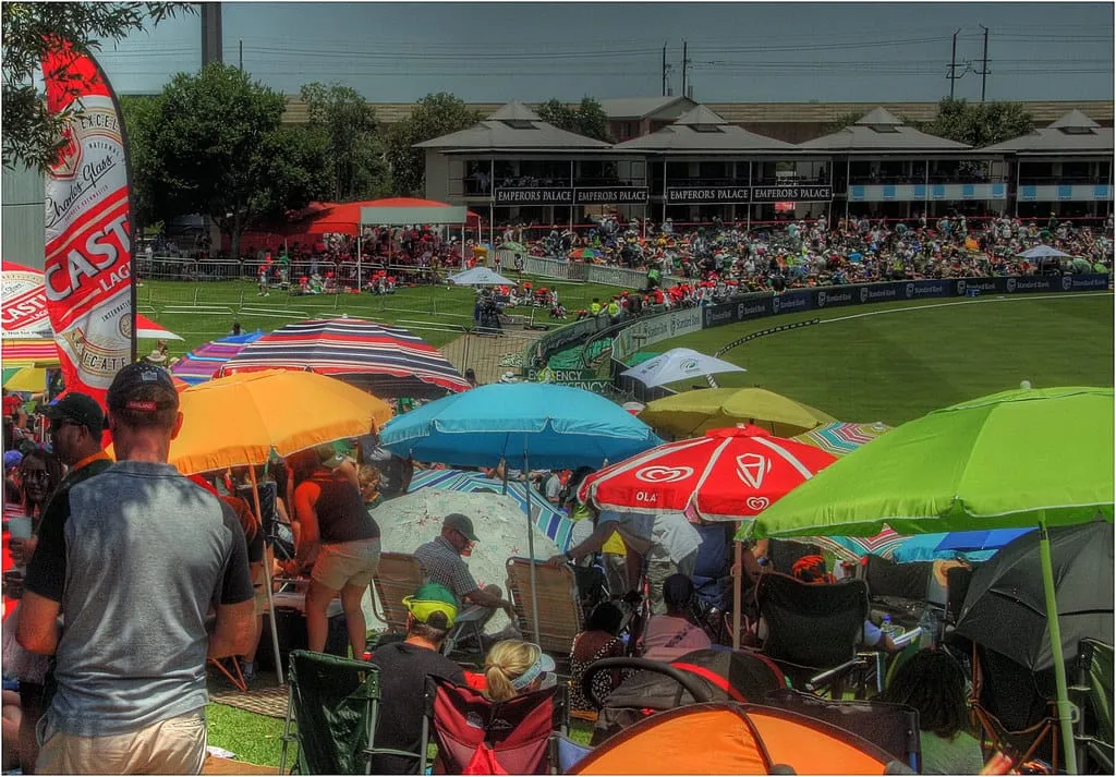Fans under umbrellas on the grass banks at SuperSport Park